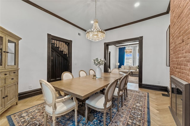 dining area with light parquet flooring, ornamental molding, and a chandelier