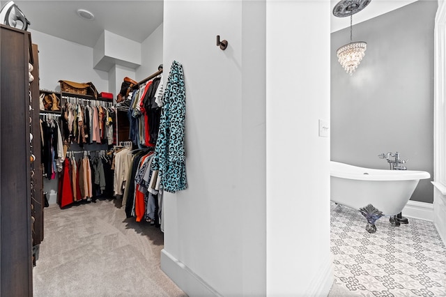 spacious closet featuring light colored carpet and a chandelier