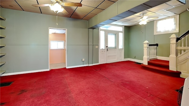 basement with ceiling fan, carpet, and a wealth of natural light