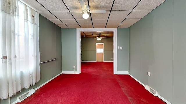 unfurnished room with a paneled ceiling, ceiling fan, and carpet flooring