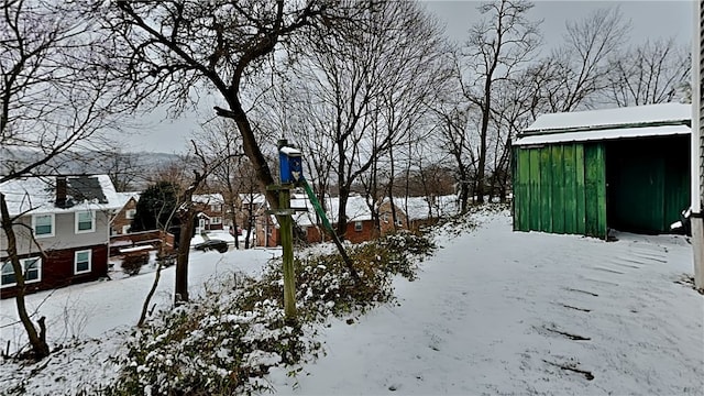 yard layered in snow with a shed