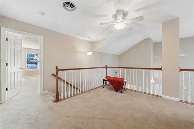 hallway with lofted ceiling and light colored carpet