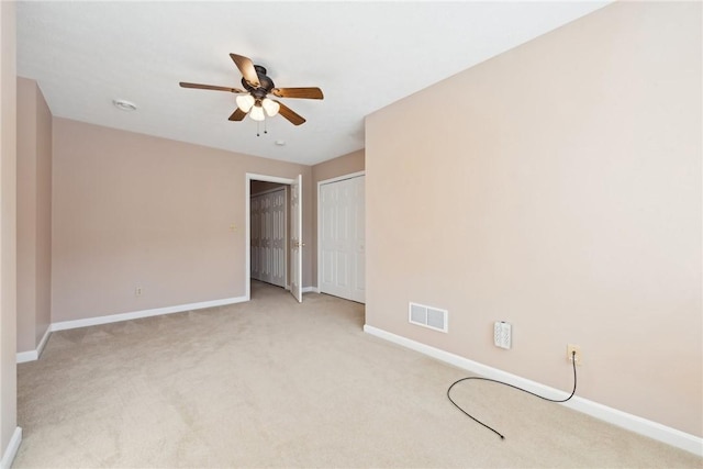 unfurnished bedroom with ceiling fan and light colored carpet