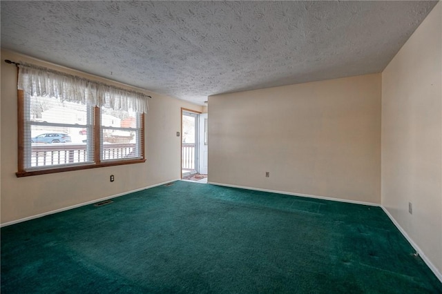 carpeted spare room with a textured ceiling