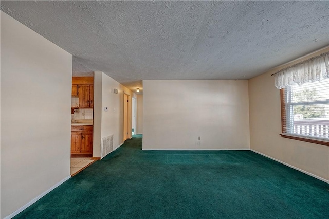 carpeted spare room with a textured ceiling