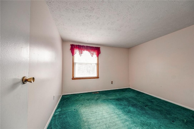 empty room with carpet floors and a textured ceiling