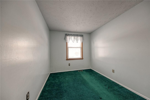 carpeted empty room with a textured ceiling