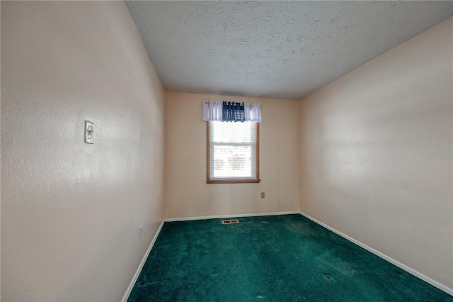 empty room with carpet and a textured ceiling