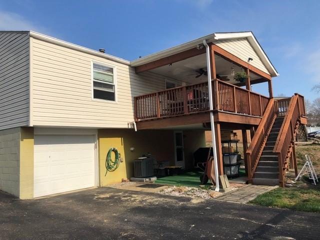 back of property featuring ceiling fan, a garage, and central AC unit