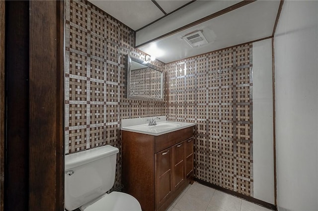 bathroom with tile patterned floors, toilet, tile walls, and vanity