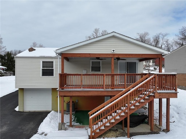 snow covered property with a garage, central AC unit, and ceiling fan