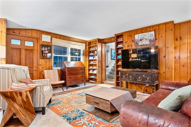 carpeted living room with built in shelves and wood walls