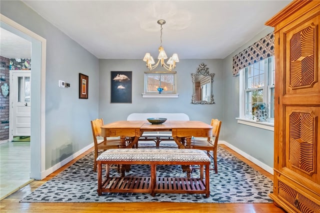 dining space with a notable chandelier and light hardwood / wood-style flooring