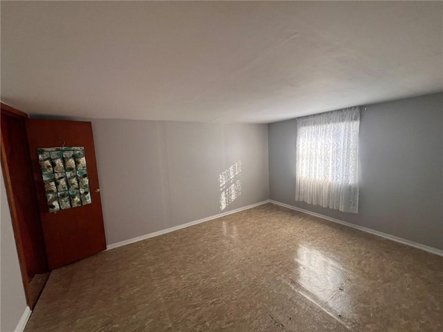 unfurnished room featuring baseboards