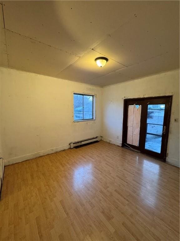 unfurnished room featuring hardwood / wood-style flooring and a baseboard radiator