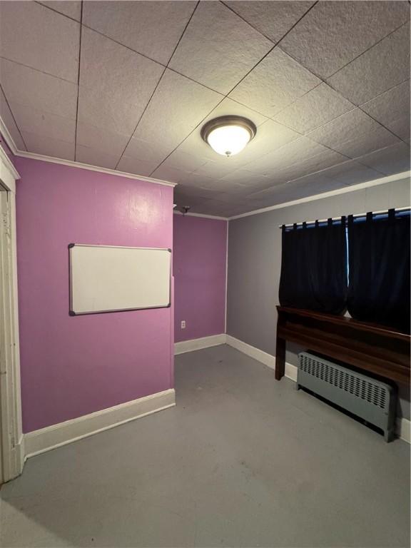 misc room featuring ornamental molding, concrete flooring, and radiator