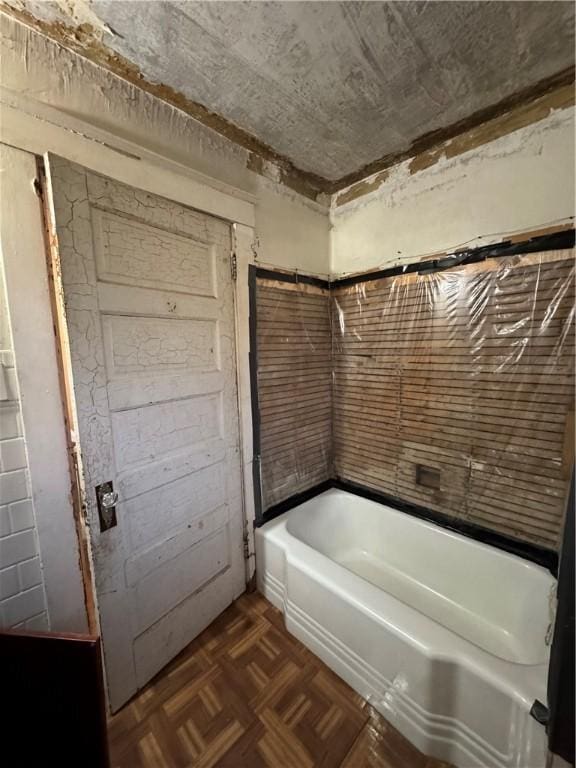 bathroom featuring parquet flooring and a bathing tub