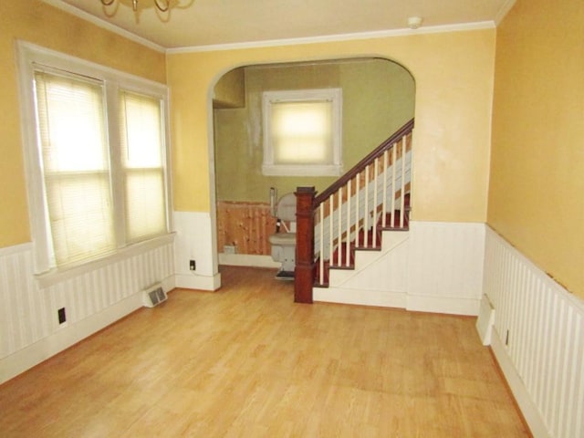 foyer entrance featuring crown molding, radiator, and hardwood / wood-style floors