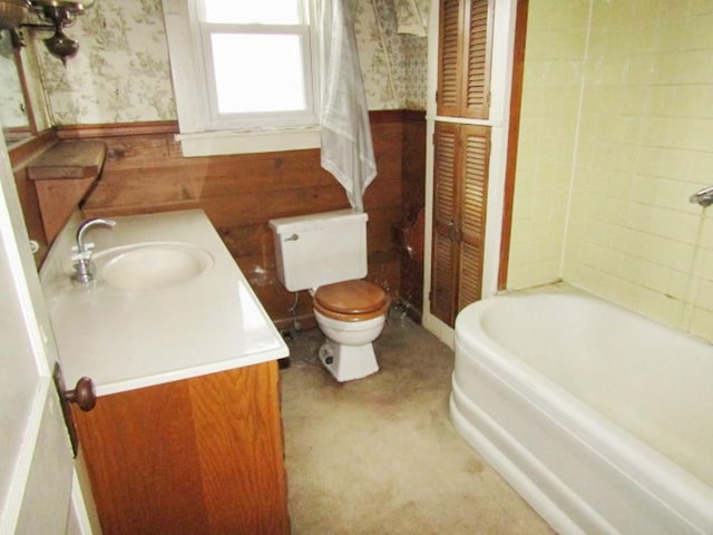 bathroom featuring vanity, toilet, and a tub to relax in