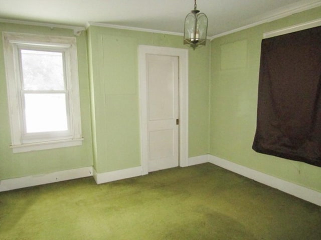 spare room featuring crown molding, an inviting chandelier, and carpet floors