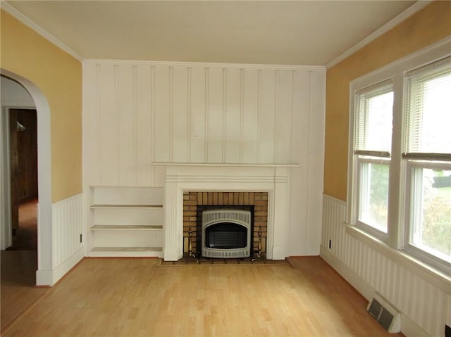 147 Carmichaels St, Dry Tav/Rices Landing, PA 15357 - unfurnished living room featuring wood finished floors, wainscoting, arched walkways, ornamental molding, and a brick fireplace