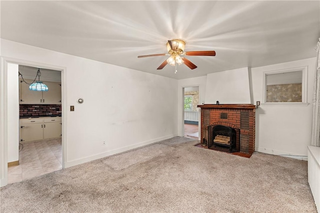 unfurnished living room with light carpet, a brick fireplace, and ceiling fan