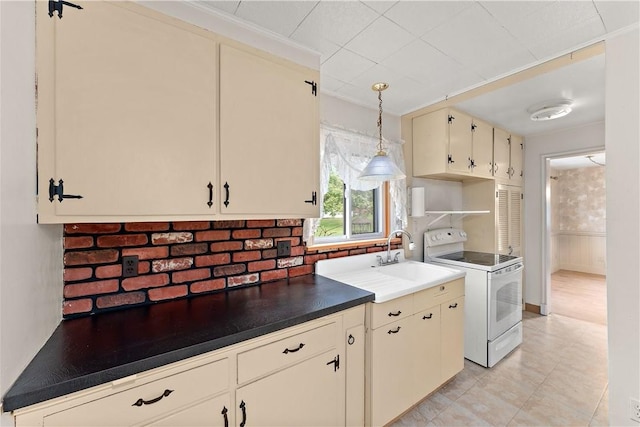 kitchen with pendant lighting, sink, ornamental molding, white electric range oven, and cream cabinets