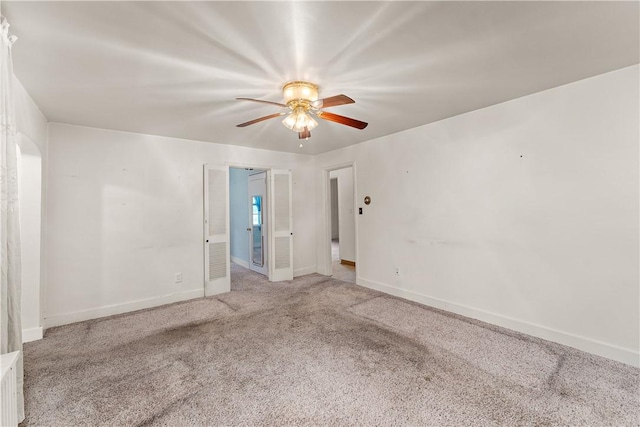 carpeted spare room with ceiling fan