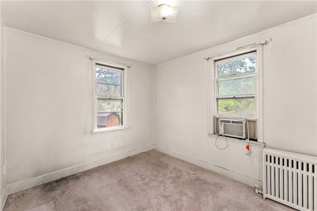 carpeted empty room with radiator and cooling unit