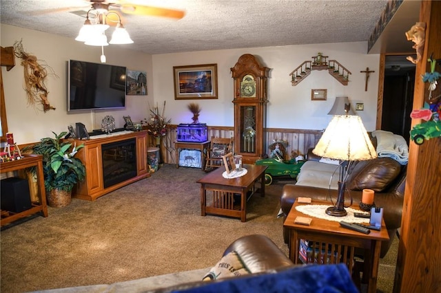 carpeted living room featuring ceiling fan and a textured ceiling