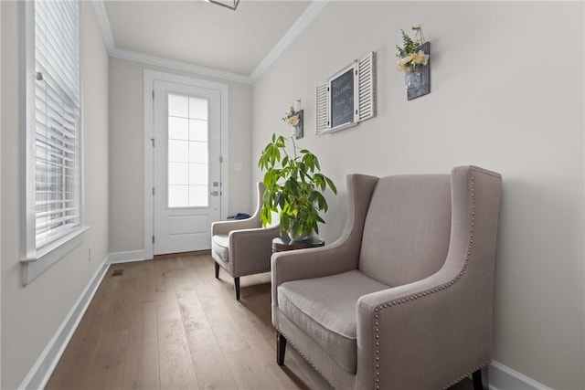 living area featuring wood-type flooring and ornamental molding