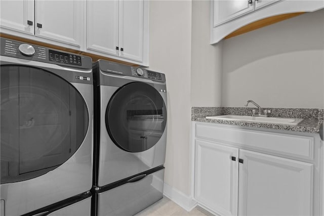 laundry room with cabinets, washer and dryer, and sink