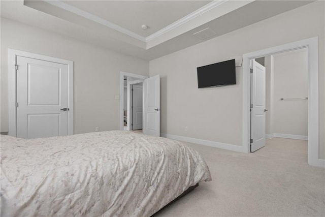 carpeted bedroom with crown molding and a raised ceiling