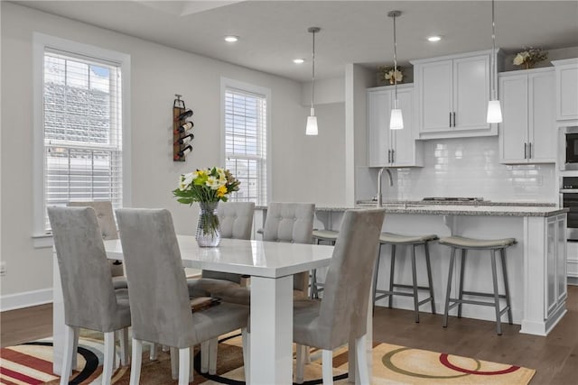 dining area with sink and dark wood-type flooring