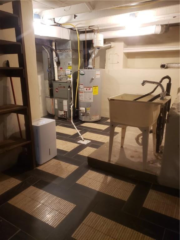 utility room with heating unit, sink, and water heater