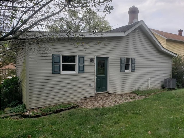 back of property with a yard and central AC unit