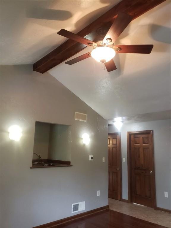 spare room with hardwood / wood-style flooring and vaulted ceiling with beams