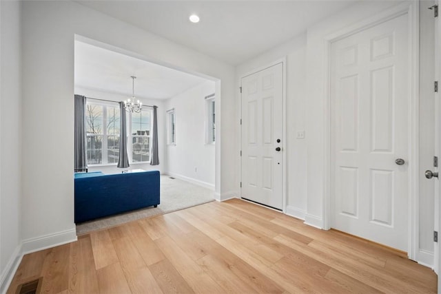 entrance foyer with hardwood / wood-style floors and a chandelier