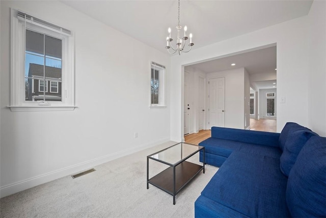 carpeted living room with a chandelier