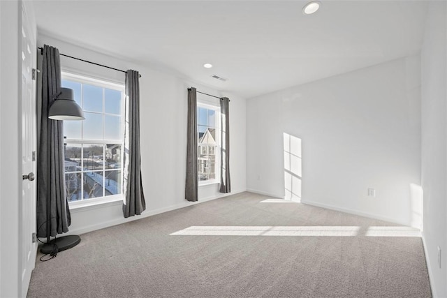 unfurnished room with light colored carpet and a healthy amount of sunlight