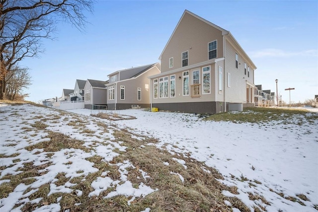 view of snow covered back of property