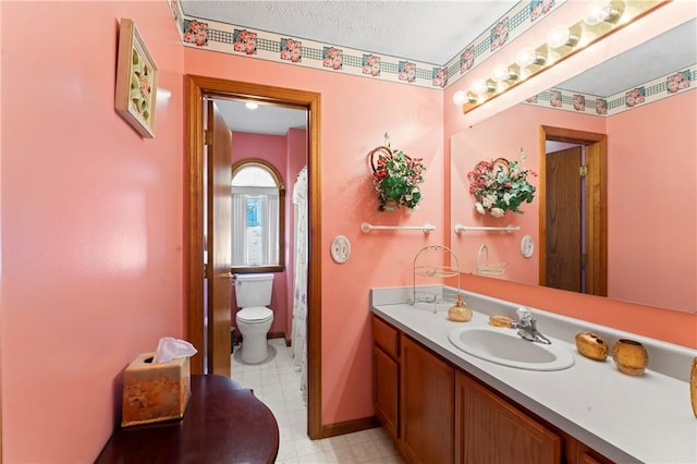 bathroom with vanity, a textured ceiling, and toilet