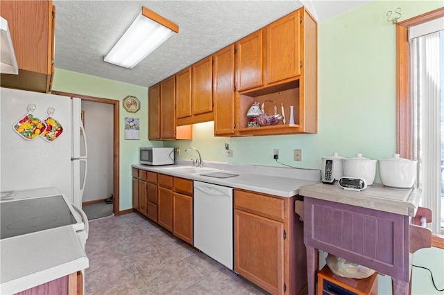 kitchen featuring sink, white appliances, and a textured ceiling