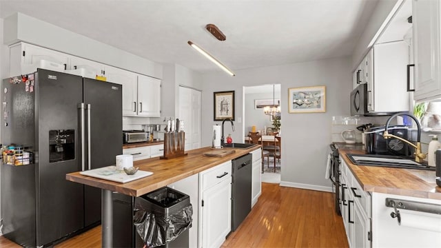 kitchen featuring butcher block counters, white cabinetry, and high quality fridge