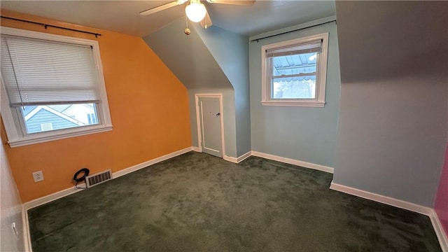 additional living space featuring ceiling fan, plenty of natural light, lofted ceiling, and dark carpet