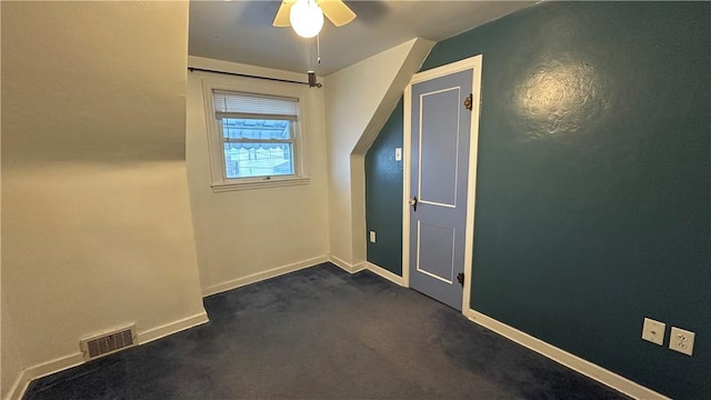 empty room with ceiling fan and dark carpet