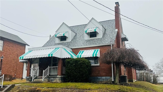 view of front facade featuring central AC unit and a front yard