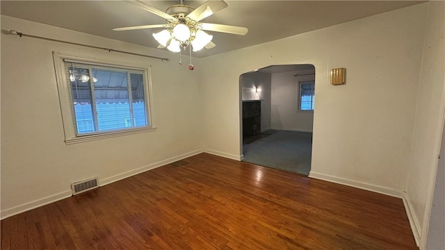 spare room with dark hardwood / wood-style floors and ceiling fan