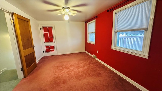 unfurnished room with ceiling fan and carpet