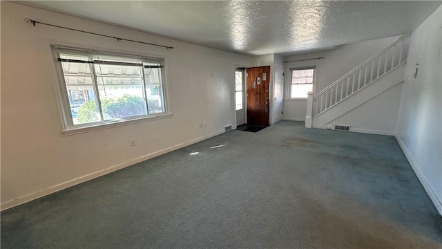 carpeted entryway with a textured ceiling